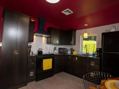 a kitchen with dark wood cabinets and a yellow towel at Modern Cottage Rental on a Peaceful Farm near Amish Country in Pennsylvania in Columbia