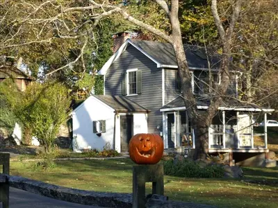 a pumpkin on a fence in front of a house at Charming Cottage Getaway with an Indoor Fireplace in Chester Springs, Pennsylvania in Chester Springs