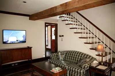 a living room with a couch and a staircase at Idyllic Cottage Getaway on a Country Estate in Chester Springs, Pennsylvania in Chester Springs