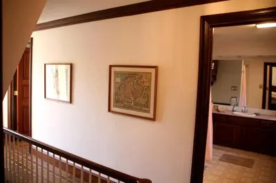 a hallway with a staircase with a mirror and a bathroom at Idyllic Cottage Getaway on a Country Estate in Chester Springs, Pennsylvania in Chester Springs