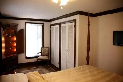 a bedroom with a bed and a window and a chair at Idyllic Cottage Getaway on a Country Estate in Chester Springs, Pennsylvania in Chester Springs