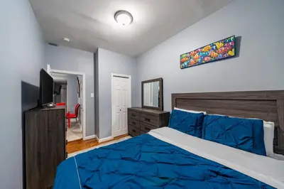 a bedroom with a blue bed and a television at Newark 3BR Gem - Near NYC - & Attractions in Newark