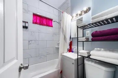 a bathroom with a tub and a toilet and a sink at Newark 3BR Gem - Near NYC - & Attractions in Newark