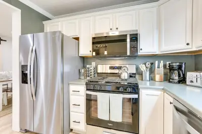 a kitchen with white cabinets and a stainless steel refrigerator at Walk to White Lake Family Home with Deck and BBQ in White Lake