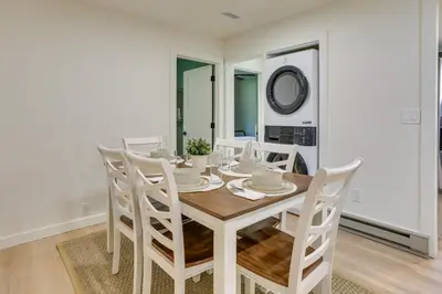 a white dining room with a wooden table and chairs at Walk to White Lake Family Home with Deck and BBQ in White Lake