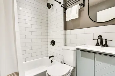 a white bathroom with a toilet and a sink at Walk to White Lake Family Home with Deck and BBQ in White Lake