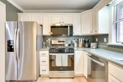 a kitchen with white cabinets and a stainless steel refrigerator at Walk to White Lake Family Home with Deck and BBQ in White Lake