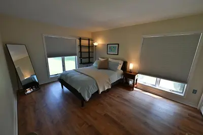 a bedroom with a bed and two windows at Farmhouse in Hershey in Hershey