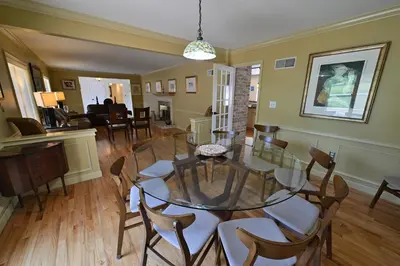 a dining room with a glass table and chairs at Farmhouse in Hershey in Hershey