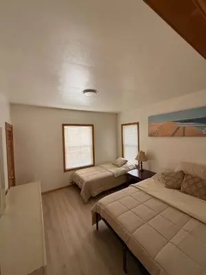 a bedroom with two beds and a painting on the wall at Cozy 3BR Apartment with Private Entry & Parking in Elizabeth, NJ in Elizabeth