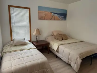 a bedroom with two beds and a table with a lamp at Cozy 3BR Apartment with Private Entry & Parking in Elizabeth, NJ in Elizabeth