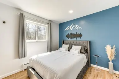 a bedroom with a large bed with a blue wall at Poconos Hot Tub Haven! 14 Mi to Camelback Resort in Pocono Country Place