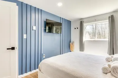 a blue bedroom with a bed and a window at Poconos Hot Tub Haven! 14 Mi to Camelback Resort in Pocono Country Place