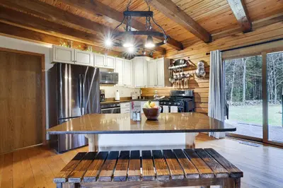 a kitchen with a large island in the middle at Secluded Escape - PAN's Wooden Casita in Lake Ariel