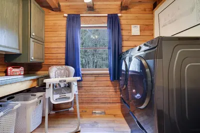 a laundry room with a washer and dryer next to a window at Secluded Escape - PAN's Wooden Casita in Lake Ariel