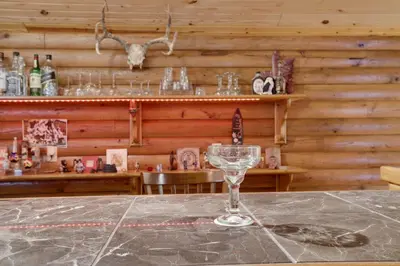 a wine glass sitting on a table in a bar at Secluded Escape - PAN's Wooden Casita in Lake Ariel