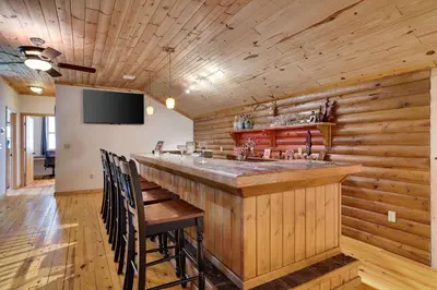 a bar with wooden walls and a flat screen tv at Secluded Escape - PAN's Wooden Casita in Lake Ariel