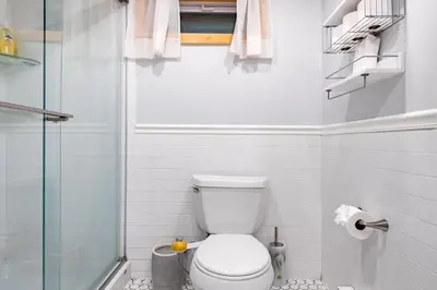 a bathroom with a toilet and a glass shower at Cozy Andes Cabin with Scenic Views in Andes