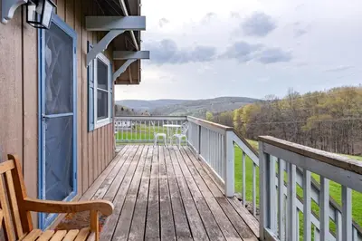 a wooden deck with a chair and tables on it at Cozy Andes Cabin with Scenic Views in Andes
