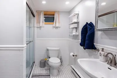 a white bathroom with a toilet and a sink at Cozy Andes Cabin with Scenic Views in Andes