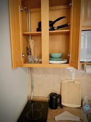 a kitchen with wooden cabinets and a counter top at Chelsea Studio 5 - Shared Bathroom - 5th Floor Walk Up in New York