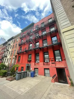 a red building with fire escapes on the side of it at Chelsea Studio 5 - Shared Bathroom - 5th Floor Walk Up in New York