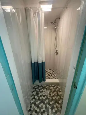 a shower with a blue and white shower curtain at Chelsea Studio 5 - Shared Bathroom - 5th Floor Walk Up in New York