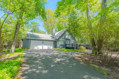a home in the woods with a driveway at Poconos Pines Retreat getaway near top attractions in Pocono Summit