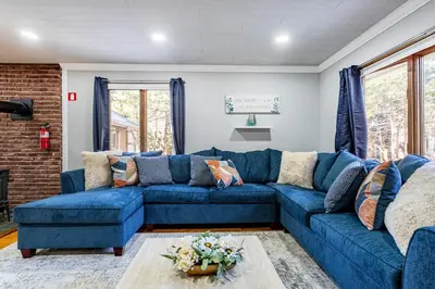 a blue couch in a living room with a brick wall at Poconos Pines Retreat getaway near top attractions in Pocono Summit