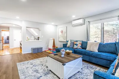 a living room with a blue couch and a table at Poconos Pines Retreat getaway near top attractions in Pocono Summit