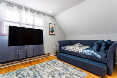 a living room with a blue couch and a flat screen tv at Poconos Pines Retreat getaway near top attractions in Pocono Summit