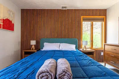 a bedroom with a blue bed and a window at Beautiful Modern Lodge! Game Room in Saw Creek