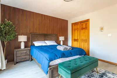 a bedroom with a blue bed and a green bench at Beautiful Modern Lodge! Game Room in Saw Creek