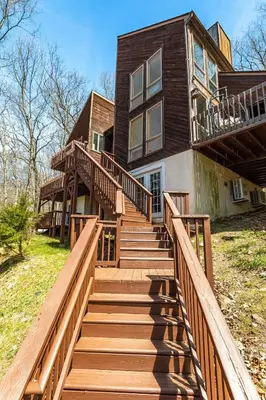 a house with wooden stairs leading up to it at Beautiful Modern Lodge! Game Room in Saw Creek
