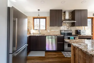 a kitchen with wooden cabinets and stainless steel appliances at Modern Rustic Lodge! Game Room in Saw Creek