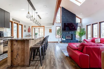 a living room with a red couch and a bar at Modern Rustic Lodge! Game Room in Saw Creek