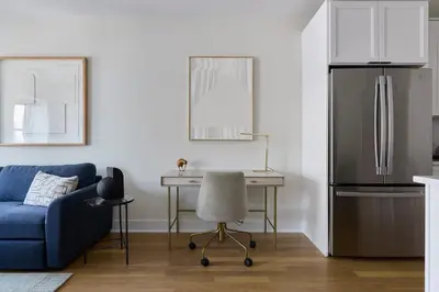 a kitchen with a blue couch and a table and a refrigerator at Hoboken Loft Hideaway - walk to PATH in Hoboken
