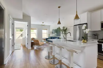 a kitchen and living room with a white counter top at Bright 3BR Loft • Hoboken Gem in Hoboken