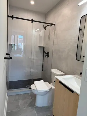 a bathroom with a shower and a toilet and a sink at Hoboken 3BR Queen Loft in Hoboken
