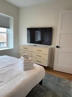 a bedroom with a tv and a bed with towels at Hoboken 3BR Queen Loft in Hoboken