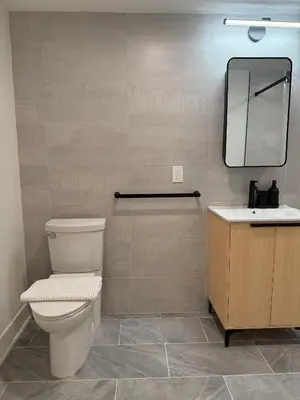 a bathroom with a toilet and a sink and a mirror at Hoboken 3BR Queen Loft in Hoboken