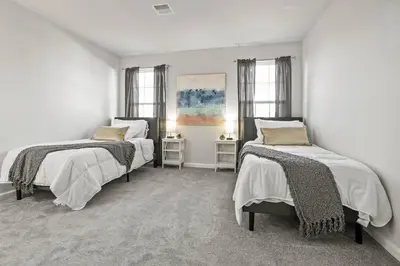 two beds in a white room with two windows at Spacious & Serene Family Gem: Games, Office, Yard! in Pennsburg