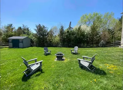 a group of chairs sitting around a fire pit in a yard at Spacious & Serene Family Gem: Games, Office, Yard! in Pennsburg