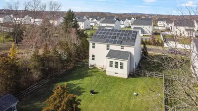 an aerial view of a white house with solar panels on it at Spacious & Serene Family Gem: Games, Office, Yard! in Pennsburg