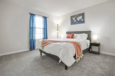 a white bedroom with a large bed and a window at Spacious & Serene Family Gem: Games, Office, Yard! in Pennsburg