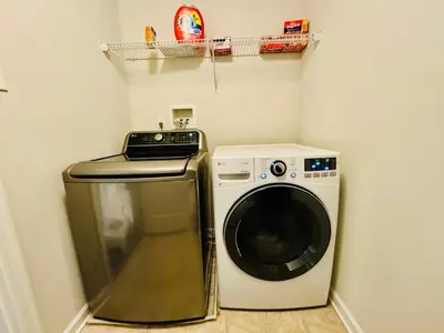 a laundry room with a washing machine and a shelf at Spacious & Serene Family Gem: Games, Office, Yard! in Pennsburg