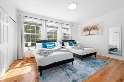 a bedroom with two beds in a room with windows at NYC 20min Free Parking Hot Tub EWR 15min in Bayonne
