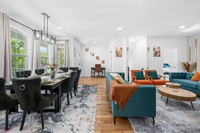 a living room and dining room with a blue couch at NYC 20min Free Parking Hot Tub EWR 15min in Bayonne