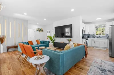 a living room with two blue couches and a kitchen at NYC 20min Free Parking Hot Tub EWR 15min in Bayonne