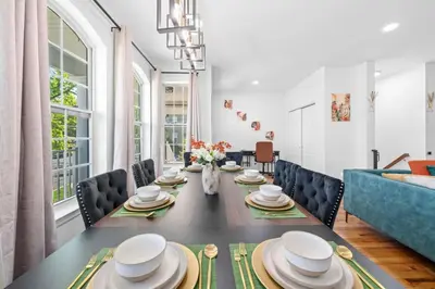 a dining room with a table and a blue couch at NYC 20min Free Parking Hot Tub EWR 15min in Bayonne